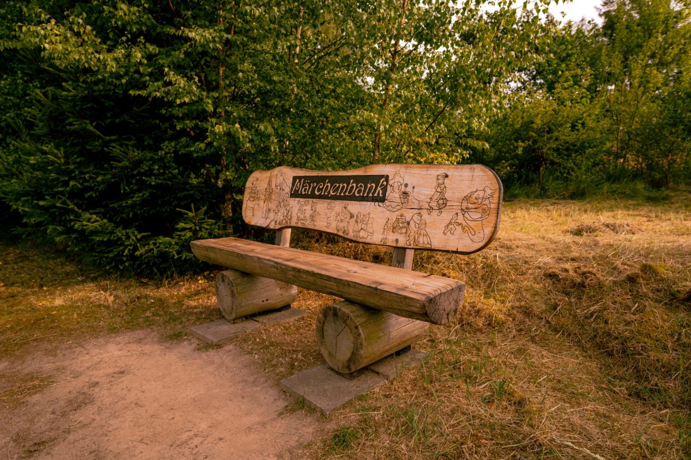 Landschaft_mit_Holzbank Holzbank im Grünen mit eingelassener Beschriftung.